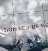 two person standing on gray tile paving