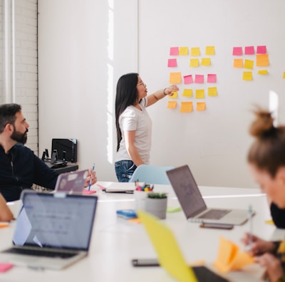 woman placing sticky notes on wall